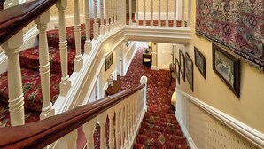 A grand staircase with ornate railings and a patterned carpet. - 4 bedroom accommodation in Aberfeldy (Aberfeldy)