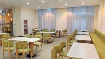 Un'area pranzo con tavoli e sedie, un bancone e una zona con una panca.