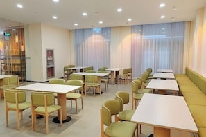 A dining area with tables and chairs, a counter, and a seating area with a bench.