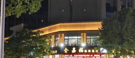 A building with illuminated signage and a crowd of people outside.