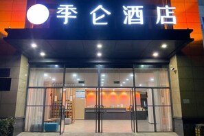 A hotel entrance with a glass facade, a reception desk, and a sign above the entrance. - JILUN HOTEL (Zhoushan)