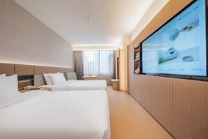 Habitación de hotel con dos camas, un televisor en la pared y una ventana con cortinas.
