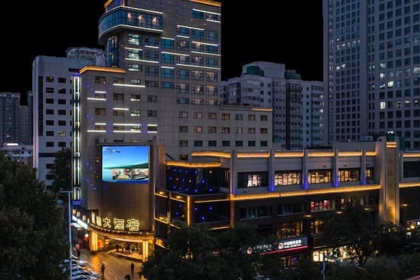 Ein Hochhaus-Hotel mit mehreren Etagen, einer auffälligen digitalen Werbeanzeige und einer gut beleuchteten Fassade.