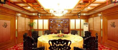 A conference room with a round table, chairs, and a chandelier.
