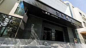 A modern hotel entrance with a prominent sign, a staircase leading up to the entrance, and a glass facade reflecting the surrounding trees. - JI Hotel (Shanghai World Expo Area Yaohua Road) (Shanghai)
