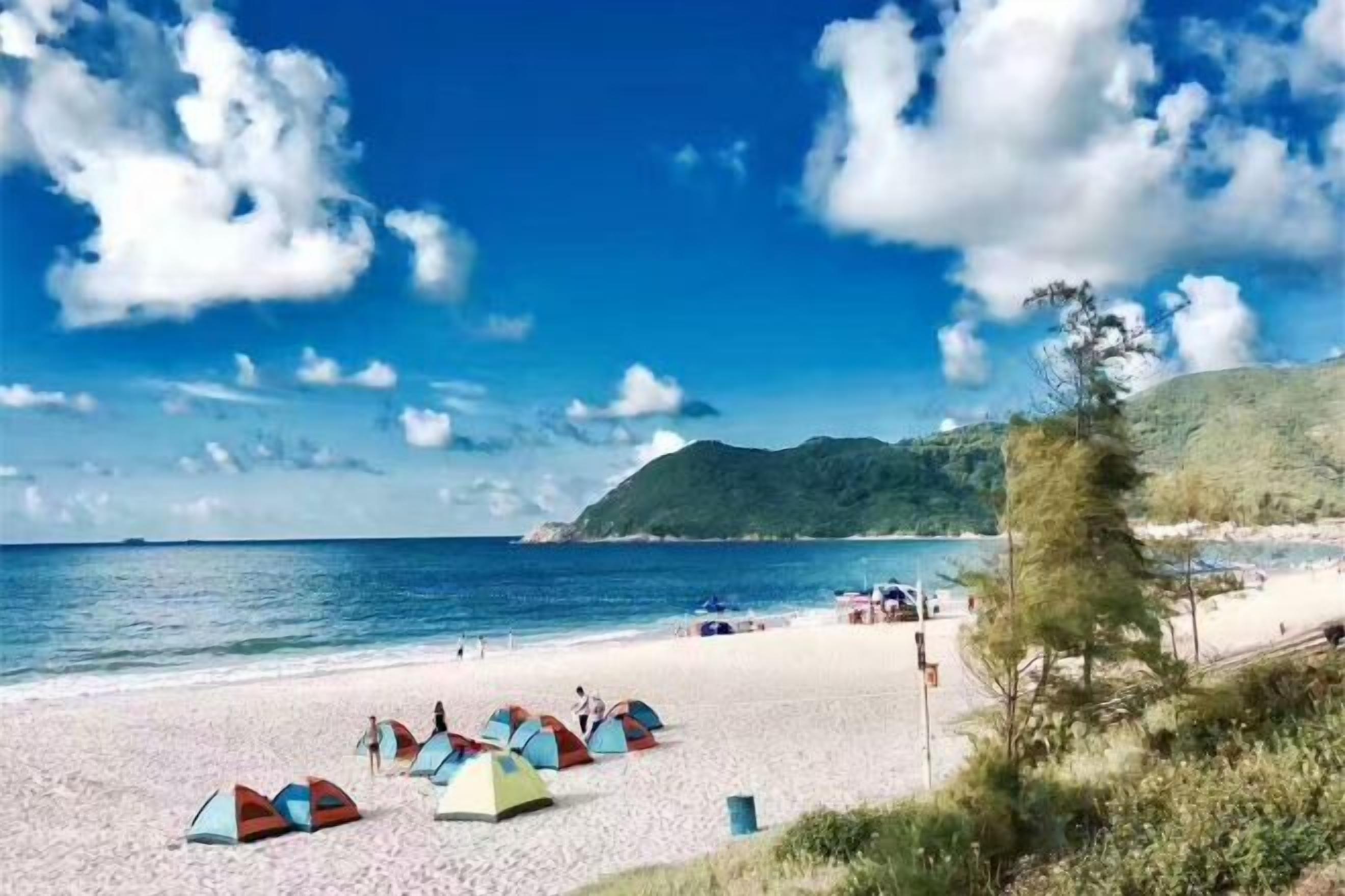 Una spiaggia con tende e cielo sereno.