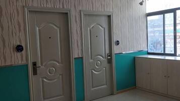 A room with two doors, a window, and a light-colored floor.