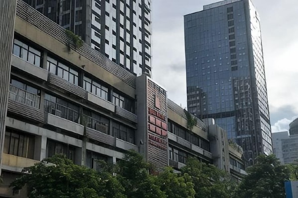 A multi-story building with a modern architectural design, featuring balconies and large windows.
