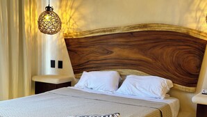 A neatly made bed with white linens and a textured blanket, a wooden headboard, and a hanging light fixture. - "Lapislázuli" Premium exotic Suite with private pool (Tulum)