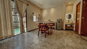 A spacious room with a dining area, a sink, and a mirror. - "Lapislázuli" Premium exotic Suite with private pool (Tulum)