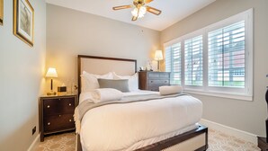 A bedroom with a bed, nightstands, a dresser, a ceiling fan, and a window with blinds. - Lundin Links - UKC6916 (Turnberry)