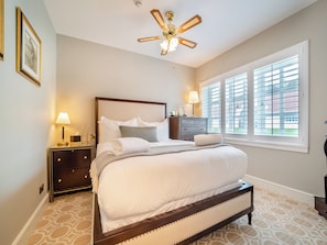 A bedroom with a bed, nightstands, a dresser, a ceiling fan, and a window with blinds. - Lundin Links - UKC6916 (Turnberry)