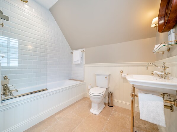 A bathroom with a bathtub, toilet, and sink.