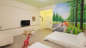 A hotel room with a television, a desk, a chair, a bed, and a mural of a forest scene. - Xigang Waipojia (Tainan)