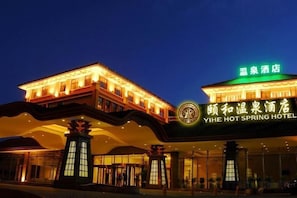 A hotel with a traditional architectural style, featuring a prominent entrance with a large sign.