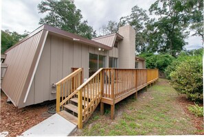 A modern house with a wooden deck and a staircase leading to a glass door. - Hidden Cabin Retreat with Private Deck & Firepit (Gainesville)