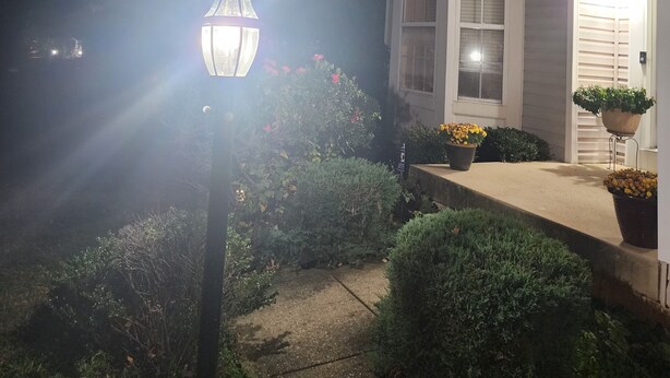 A house at night with a lit street lamp, a front porch with potted plants, and a well-maintained garden. - Charming 1-bedroom house in wonderful Severn with office,   WiFi, fitness room (Severn)