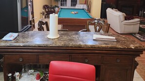 A living room with a pool table, a red chair, a fireplace, and a television. - Charming 1-bedroom house in wonderful Severn with office,   WiFi, fitness room (Severn)