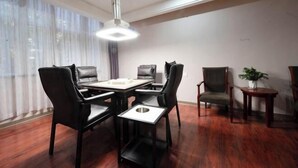Un comedor con una mesa redonda, sillas negras y una lámpara colgante.