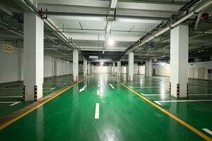 Un parcheggio multipiano con pavimento verde e posti auto bianchi.
