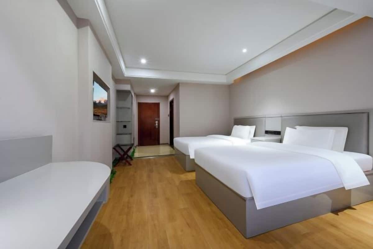 Een moderne hotelkamer met een groot bed, een bureau en uitzicht op de gang.