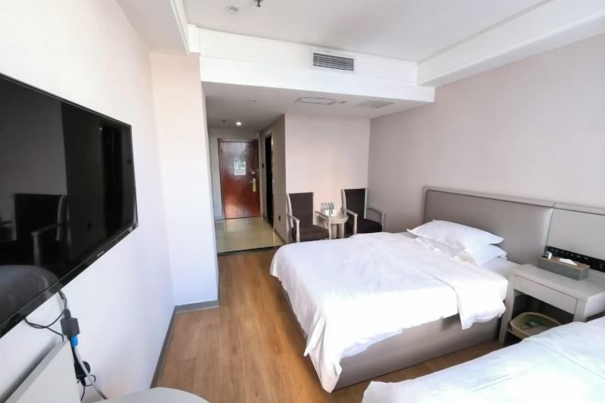 Une chambre d’hôtel avec un lit, une table de chevet et un téléviseur.