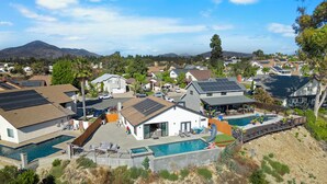 A residential area with houses, a swimming pool, and solar panels.