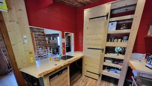 A compact kitchen with wooden cabinets, a sink, and a stove.