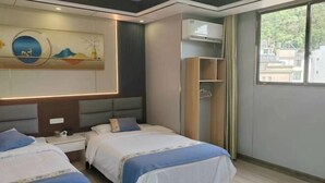 A hotel room with two beds, a wardrobe, a wall-mounted artwork, and a window with a view of buildings. - Guiping Country House, Guili Ancient Town (Fuliang)