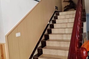 A staircase with a wooden handrail and beige carpeted steps. - Guiping Country House, Guili Ancient Town (Fuliang)