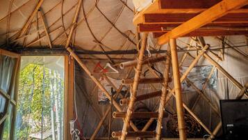 Una habitación con estructura de techo de madera, un tragaluz y una escalera de caracol.