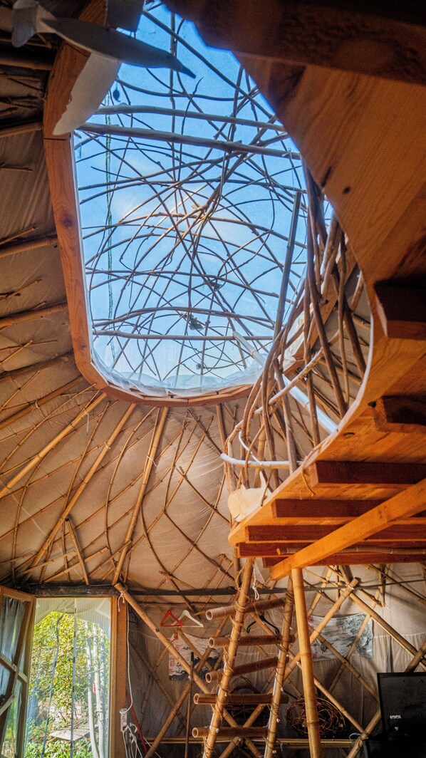 A room with a wooden ceiling structure, a skylight, and a spiral staircase. - Logements Nature et Soins Pour se Ressourcer (Saint-Antonin-Noble-Val)
