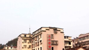Un immeuble à plusieurs étages, dont la façade est ornée d’une grande enseigne rouge.