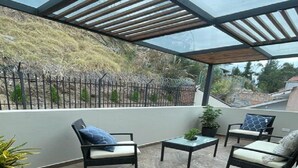 A covered patio with a glass ceiling, outdoor seating, and a view of a hillside. - 2BR duplex with city views.  "Casa Colibrí" (Cuenca)