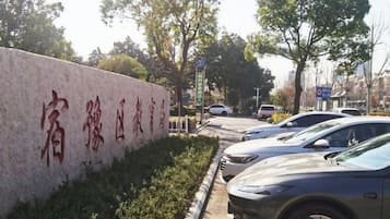 A parking area with a stone wall and a sign with Chinese characters.