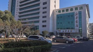 A hotel building with multiple floors and a parking lot in front. - GreenTree Inn Express Hotel (Suqian Xiangwang East Road Suyu Bureau of Education Branch) (Suqian)