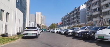 Una calle bordeada por coches aparcados y edificios de varios pisos.