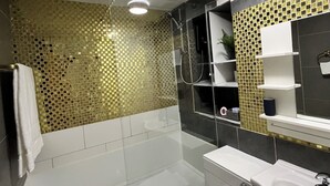 Een moderne badkamer met een bad, toilet en wastafel.