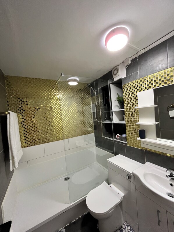 A modern bathroom with a bathtub, toilet, and sink.