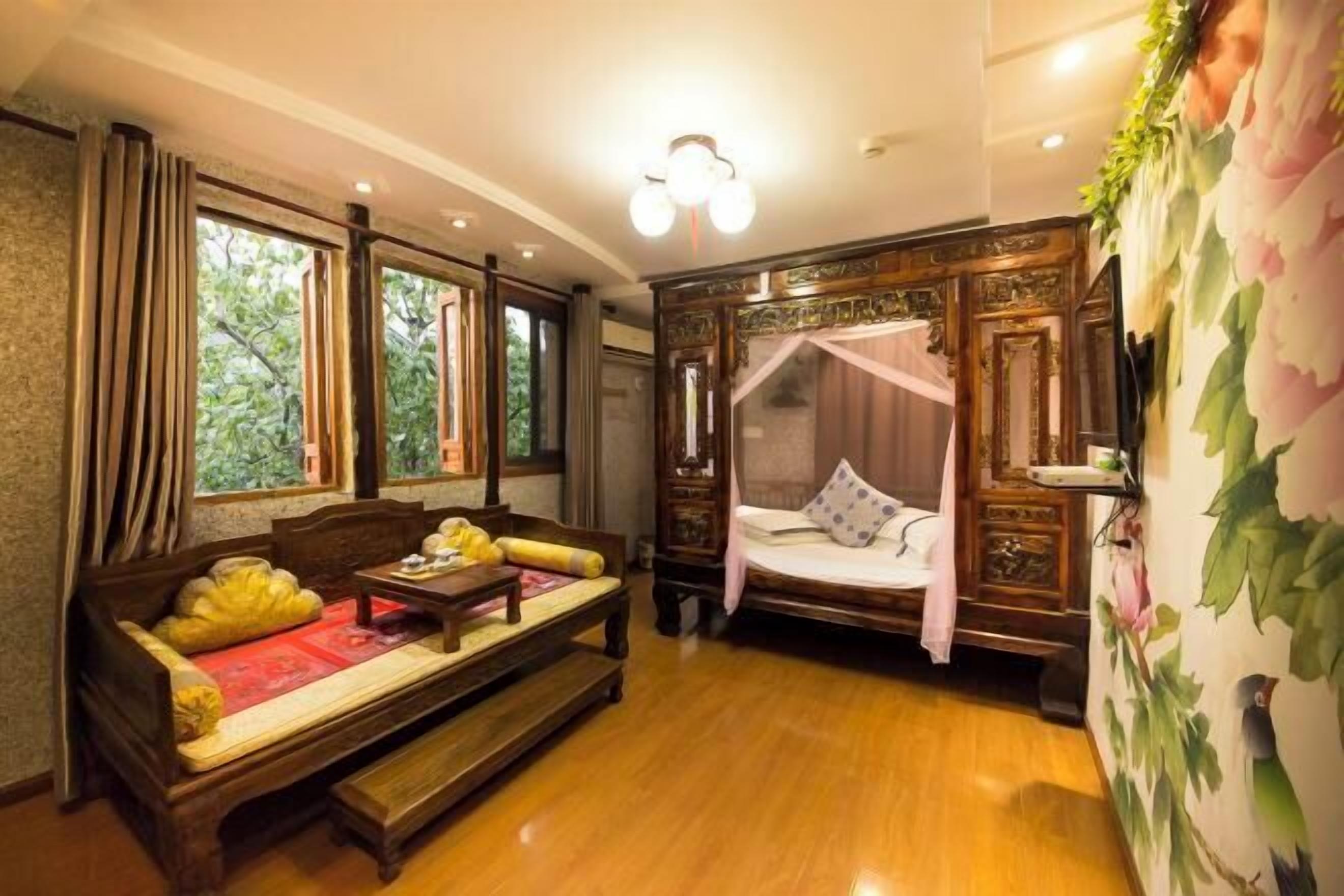 A traditional room with a wooden bed, a sofa, and a bench.