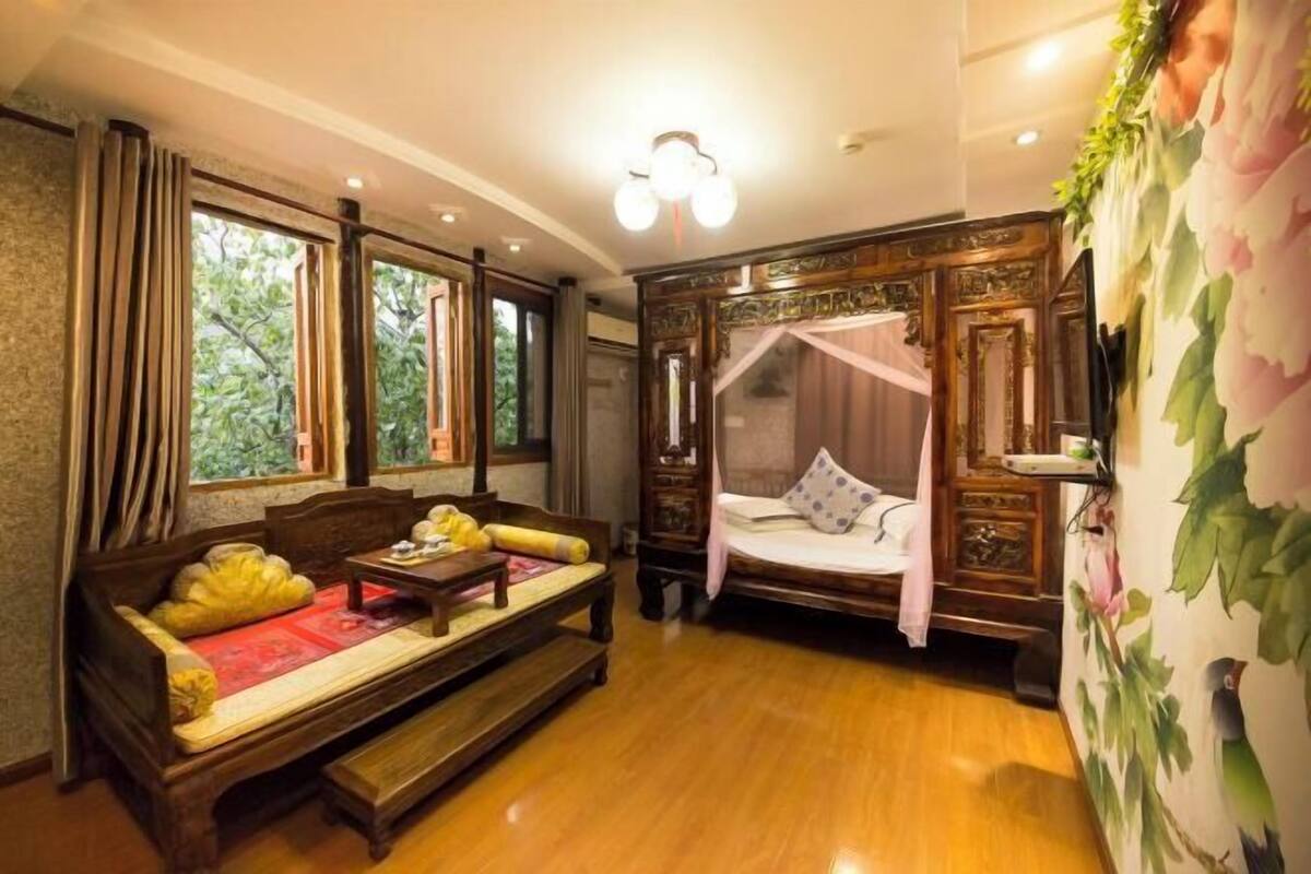 Une chambre de style traditionnel, avec un lit en bois, un canapé et un banc.