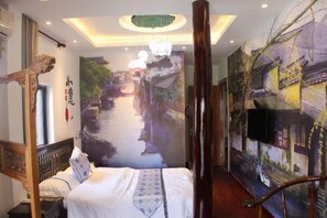 A hotel room with a bed, a wall mural, and a ceiling light fixture. - Kelaiju Inn (Suzhou)
