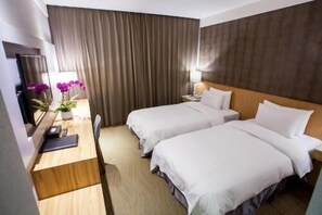 A hotel room with two beds, a desk with a lamp, and a mirror. - Cloud Hotel (Taipei)