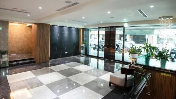 A hotel lobby with a checkered floor, a reception desk, and a view of the street through large windows. - Cloud Hotel (Taipei)