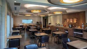 A modern restaurant interior with multiple dining tables and chairs, a bar area, and pendant lighting. - Cloud Hotel (Taipei)