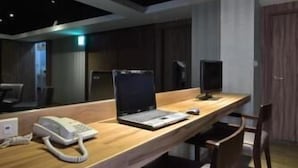 A modern office space with a wooden desk, a laptop, a telephone, and two chairs. - Cloud Hotel (Taipei)