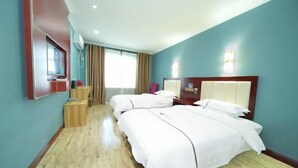 A hotel room with two beds, a wooden floor, a TV, and a window with curtains. - Jinghe Heli Hotel (Jinghe)