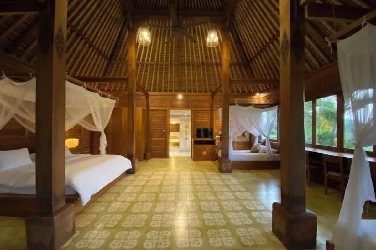 Een kamer met een kamer met een patroon vloer, houten balken en een hemelbed.
