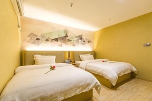 Una habitación de hotel con dos camas, una obra de arte en la pared y una mesita con un teléfono.