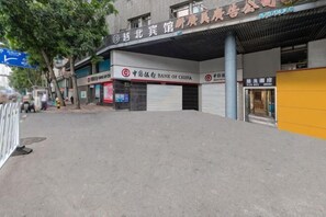 Vista de la calle con una sucursal bancaria cerrada y un edificio con un letrero que dice 'CHINA BANK OF CHINA'.
